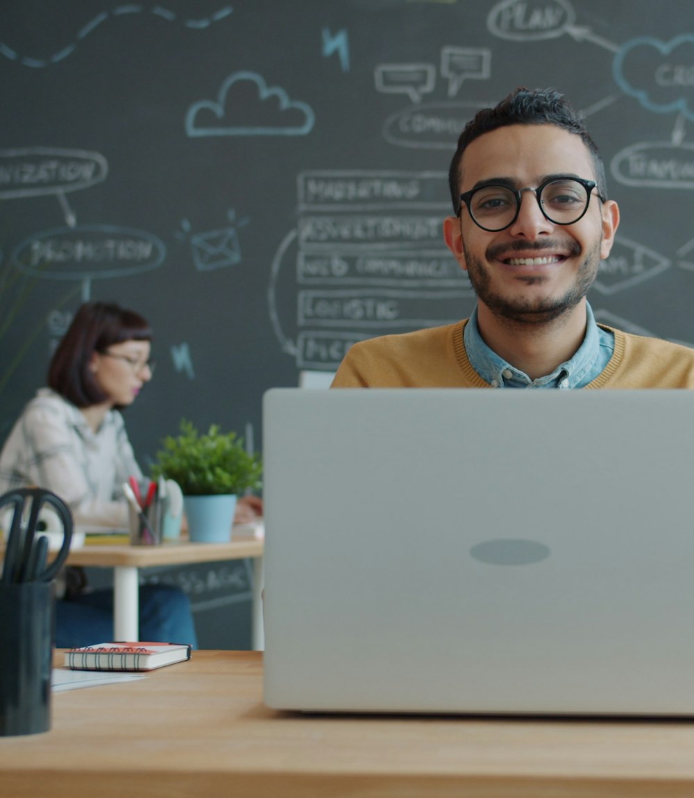 Smilende koereskoleejer arbejder pa baerbar computer